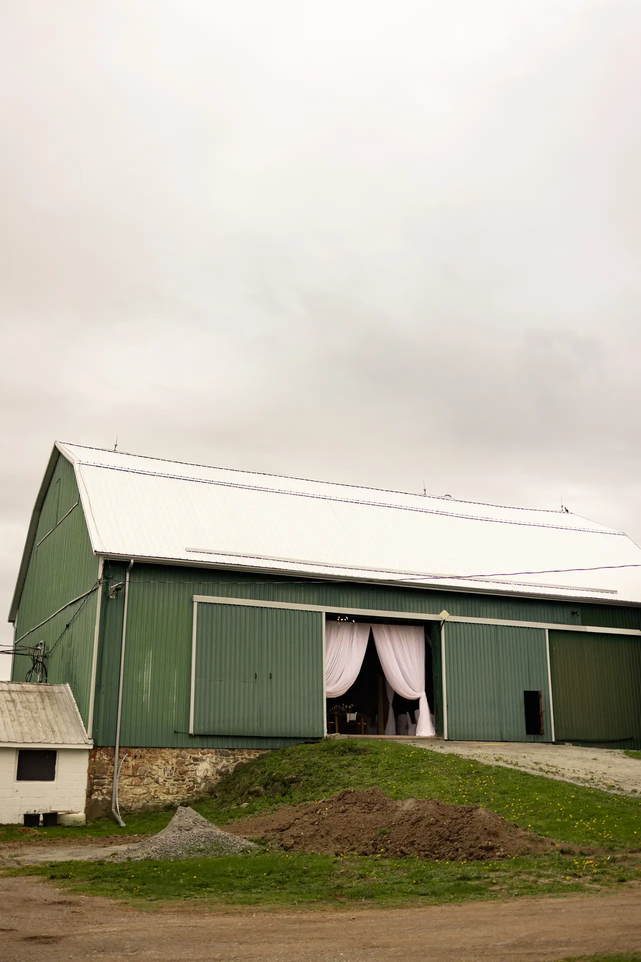 Green barn wedding venue with draped entrance in the Peterborough and Kawarthas region